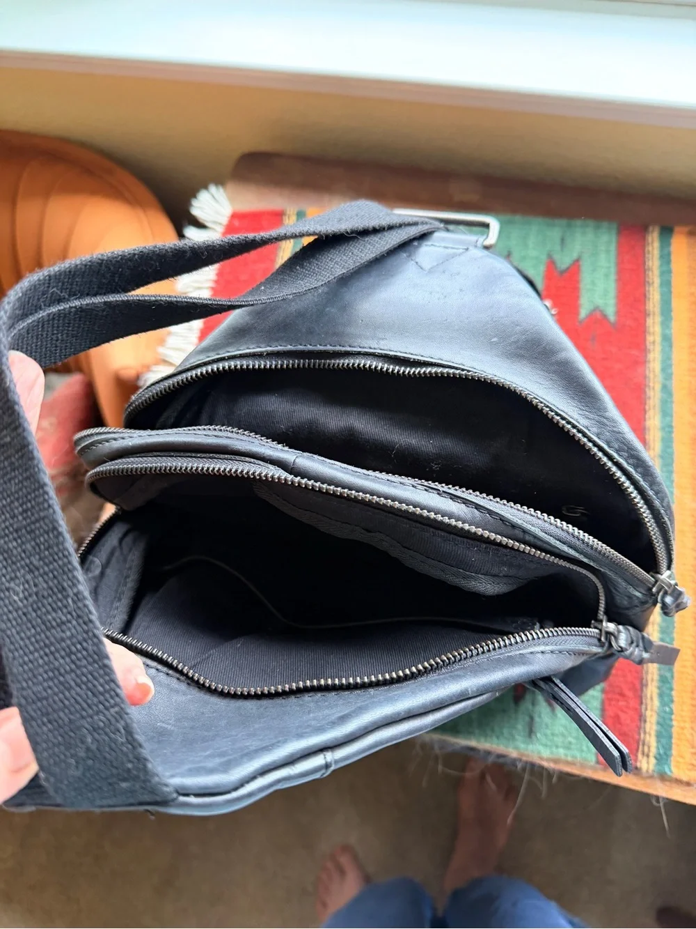 Black trianglular leather backpack with multiple pockets